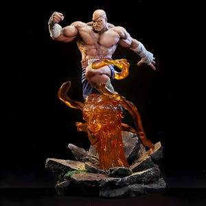 May include: A detailed figurine of a muscular, bald character with a scar over one eye, wearing blue shorts and wrist wraps. The figure is posed mid-action, with a fiery orange energy effect emanating from the base, set on a rocky platform.