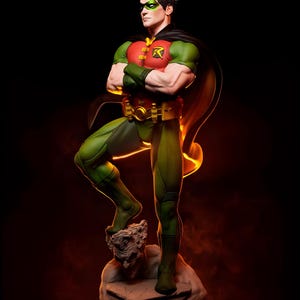 May include: A detailed statue of Robin, a DC Comics superhero, in a dynamic pose. The figure wears a green and red costume with a black cape, green mask, and a gold belt. The statue is standing on a stone base with a sculpted face.