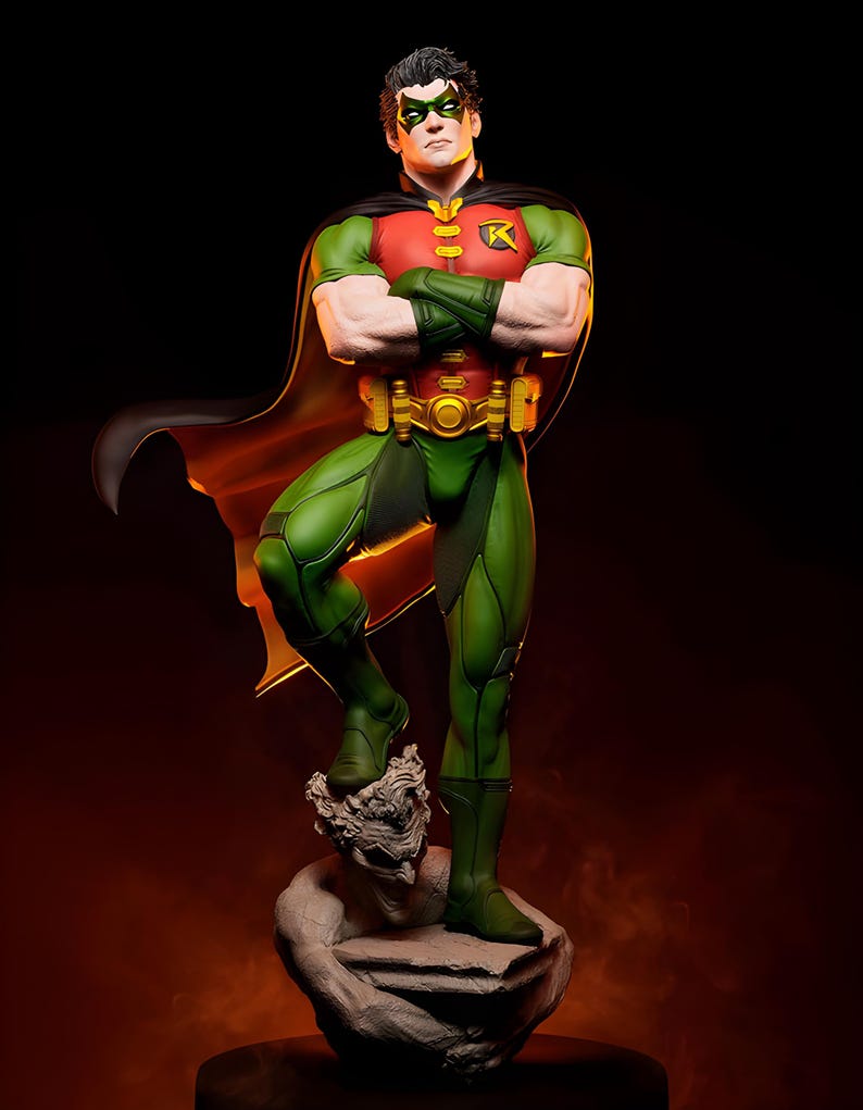 May include: A detailed statue of Robin, a DC Comics superhero, in a dynamic pose. The figure wears a green and red costume with a black cape and mask. The statue stands on a stone base, with arms crossed, and a confident expression.