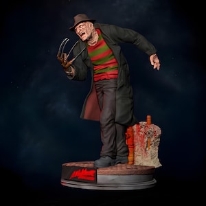 Könnte beinhalten: Detaillierte Figur einer Horrorfilmfigur, die einen Fedora, einen gestreiften Pullover und einen Trenchcoat mit Klingen trägt. Die Figur steht auf einem kreisförmigen Sockel mit dem Wort "Nightmare" in Rot.