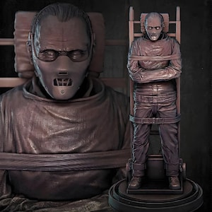May include: A brown sculpture of a person wearing a mask and restraints, with a second sculpture of a person strapped to a chair. The sculptures are detailed and appear to be based on a movie character.