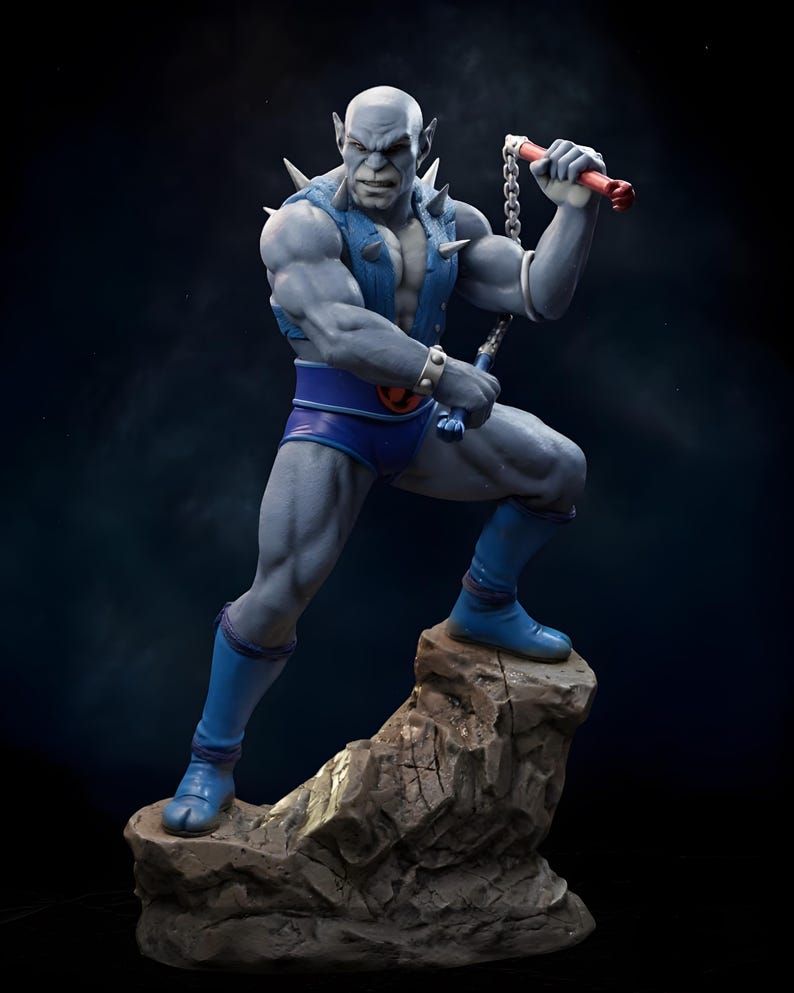 Puede incluir: Estatua detallada de una figura humanoide musculosa de piel gris en una pose din&aacute;mica. La figura lleva pantalones cortos azules, botas y un chaleco con p&uacute;as plateadas. Sostiene un arma de cadena con mangos rojos, de pie sobre una base rocosa.