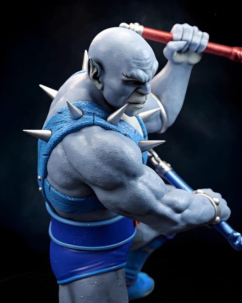Puede incluir: Figura detallada de una figura humanoide musculosa de piel azul. La figura est&aacute; vestida con una armadura azul con p&uacute;as plateadas y sostiene un bast&oacute;n rojo y azul. El personaje tiene una expresi&oacute;n severa y est&aacute; en una postura de acci&oacute;n din&aacute;mica.