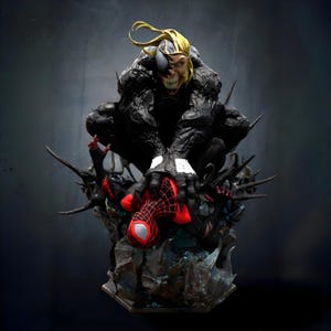 Puede incluir: Una estatua detallada de Venom, un simbionte negro, dominando una figura de Spider-Man roja y negra. La cara de Venom está dividida, mostrando rasgos humanos y simbióticos. La base es un entorno oscuro y rocoso.