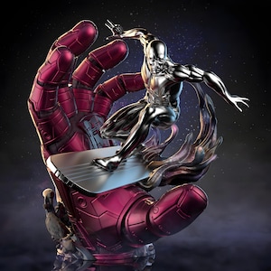 Puede incluir: Una escultura detallada de Silver Surfer montando una tabla de surf, encima de una gran mano roja metálica. La figura es plateada y la mano es de un rojo intenso. El fondo es un espacio oscuro con estrellas.