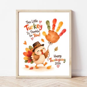 Puede incluir: Una impresión enmarcada con un pavo de dibujos animados con sombrero marrón, sosteniendo un globo de huella de mano en colores otoñales. El texto dice: This Little Turkey Is Thankful for You! Happy Thanksgiving 2026. Incluye corazones y hojas.