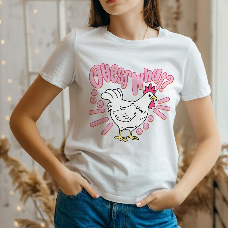 Lifestyle mockup of a preppy girl wearing a white oversized t-shirt featuring the funny pink Guess What Chicken Butt matching front and back sublimation designs.