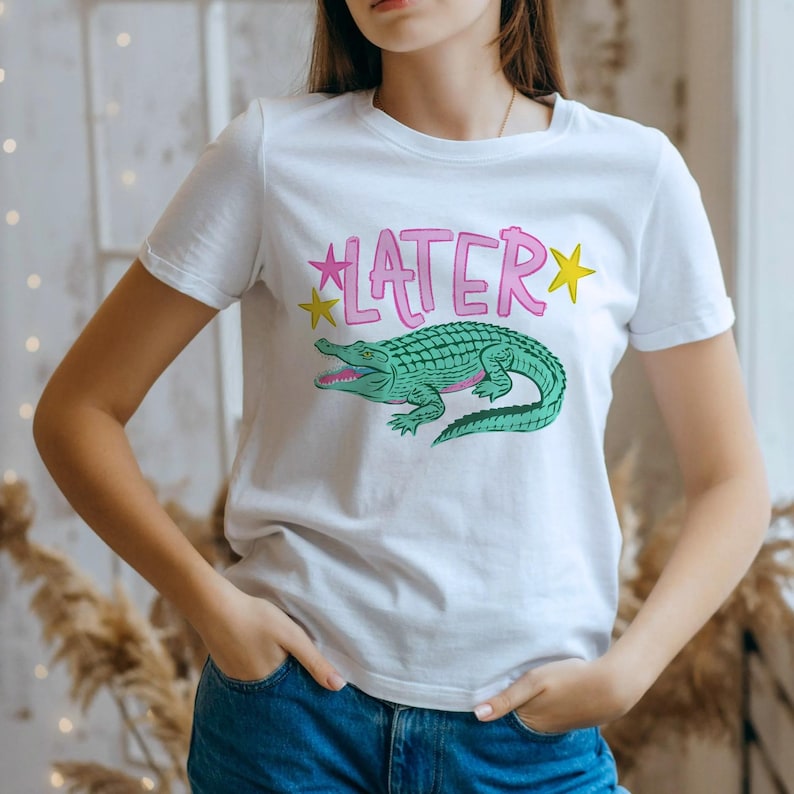 Hand-drawn teal and pink alligator with bold blue graffiti "LATER" text and green stars, boy aesthetic preppy streetwear style for sublimation and DTF.