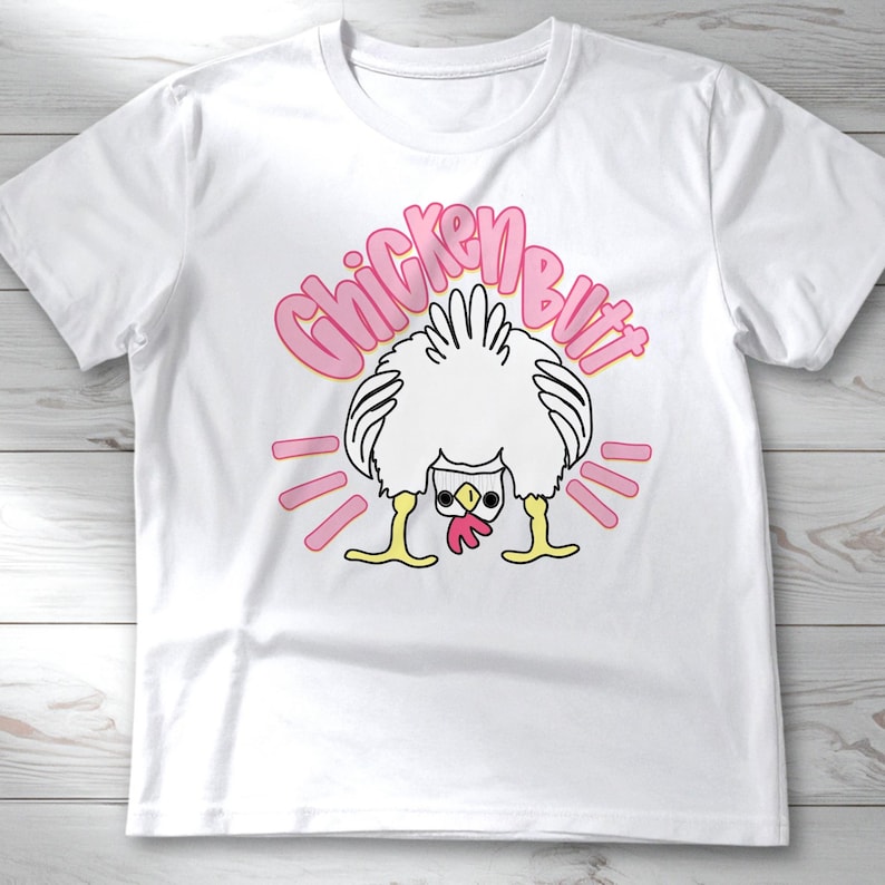 Lifestyle mockup of a preppy girl wearing a white oversized t-shirt featuring the funny pink Guess What Chicken Butt matching front and back sublimation designs.
