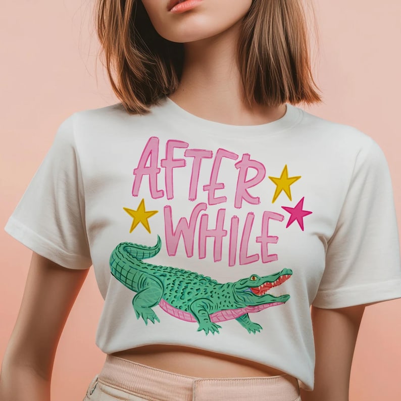 Detailed teal and pink crocodile illustration with "AFTER WHILE" blue hand-lettered graffiti font and green stars, trending boy boutique design for kids' apparel.