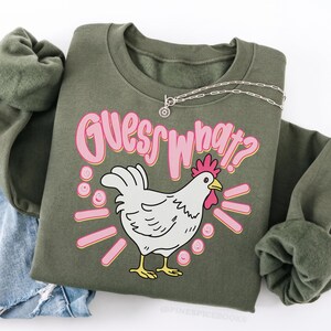 Lifestyle mockup of a preppy girl wearing a white oversized t-shirt featuring the funny pink Guess What Chicken Butt matching front and back sublimation designs.