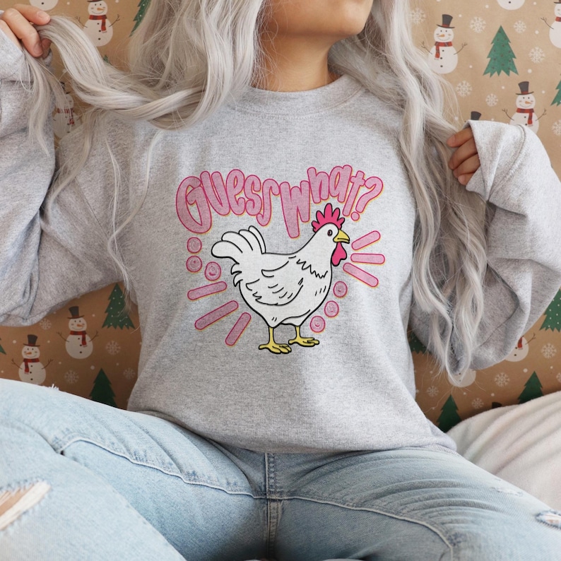 Lifestyle mockup of a preppy girl wearing a white oversized t-shirt featuring the funny pink Guess What Chicken Butt matching front and back sublimation designs.
