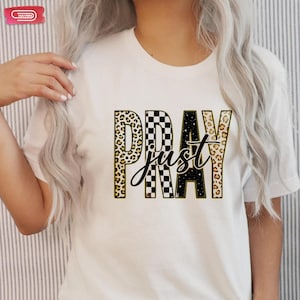 Bold "PRAY" text with leopard, checkerboard, and starry patterns, overlaid with a cursive "just" script, featuring a gold outline.