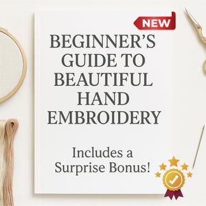 May include: A white book titled "Beginner's Guide to Beautiful Hand Embroidery" with the word "NEW" on a red tag. Includes a surprise bonus! Embroidery hoop, thread, scissors, and needle are also visible.