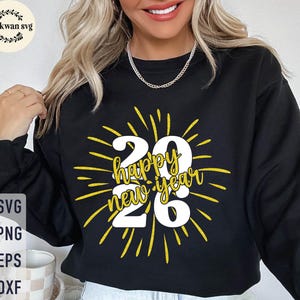 以下が含まれることがあります： 「26 Happy New Year」と書かれた黄色と白のグラフィックが特徴の黒いスウェットシャツ。デザインは、数字とテキストから放射状に広がる黄色の線が特徴です。画像には「SVG、PNG、EPS、DXF」というテキストも含まれています。