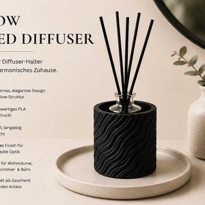 May include: A black cylindrical reed diffuser holder with a wavy, textured surface. The holder contains a clear glass bottle with five thin black reeds. Text on the left reads FLOW REED DIFFUSER, Stilvoller Diffuser-Halter für ein harmonisches Zuhause.