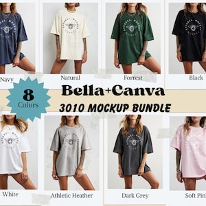 Op de afbeelding: Een mockup-bundel met acht verschillende kleuren oversized t-shirts. Elk shirt heeft een cirkelvormige afbeelding met een bij en de tekst "Apparel Mockup". Kleuren zijn marine, naturel, bos, zwart, wit, athletic heather, donkergrijs en zachtroze.