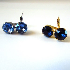 May include: A pair of earrings with blue gemstone accents. One pair has silver-toned ear wires and the other pair has gold-toned ear wires.