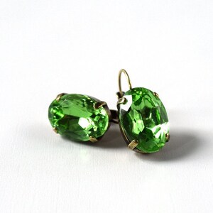 May include: A pair of green oval-shaped earrings with a gold-tone setting.