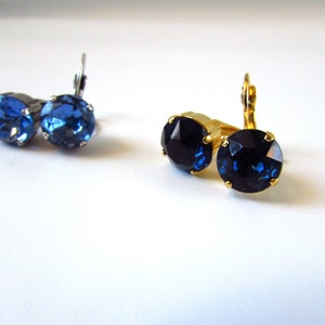 May include: Two pairs of earrings with blue rhinestones. One pair has silver settings and the other has gold settings.