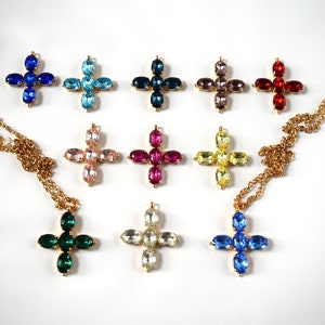 May include: Ten gold cross pendants with different colored crystal stones. The stones are in shades of blue, green, pink, red, yellow, and clear.