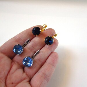 May include: Three pairs of earrings with blue and black gemstones. The earrings have a gold and silver finish.