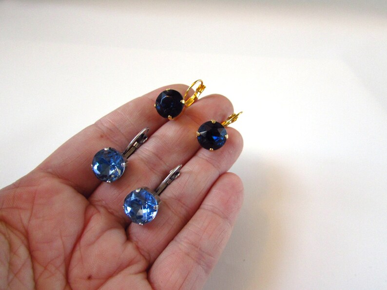 May include: Three pairs of earrings with blue and black gemstones. The earrings have a gold and silver finish.