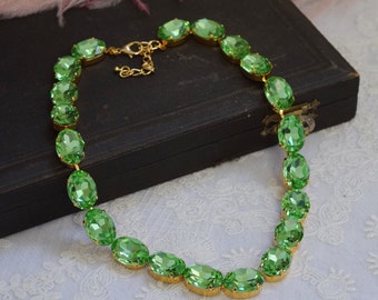 Puede incluir: Un collar de cristal verde con piedras de forma ovalada y un cierre dorado.