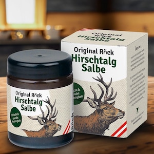 May include: A jar and box of Original Röck Hirschtalg Salbe, featuring a deer illustration. The jar has a dark colour with a black lid, and the box is white with red stripes. The text "Original Röck Hirschtalg Salbe" is displayed.