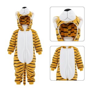 May include: A yellow and black striped tiger-themed jumpsuit with a hood. The jumpsuit has a white front and a zipper closure. The hood features a tiger face with white ears and a black nose. The outfit is designed for children.