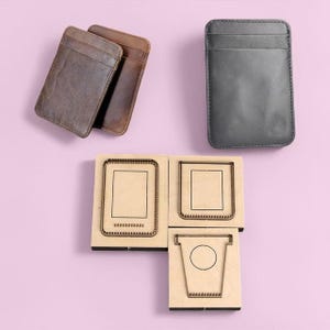 Könnte beinhalten: Drei Lederkartenhalter in Braun- und Grautönen sowie Holzstanzvorlagen zum Basteln. Die Kartenhalter haben ein minimalistisches Design. Die Holzvorlagen weisen rechteckige und becherförmige Aussparungen auf, ideal für Lederarbeiten.
