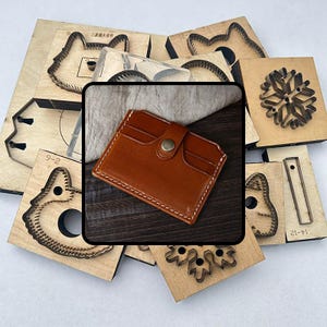 Puede incluir: Un tarjetero de cuero marrón con costuras blancas y un cierre de botón metálico. El tarjetero está rodeado de varias formas troqueladas de madera, incluyendo diseños de animales y copos de nieve, utilizadas para manualidades.