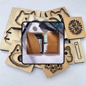 May include: A brown leather wallet with multiple card slots and cash. A black watch, pen, coin, and smartphone are next to the wallet. Wooden die-cut shapes in various designs surround the wallet.