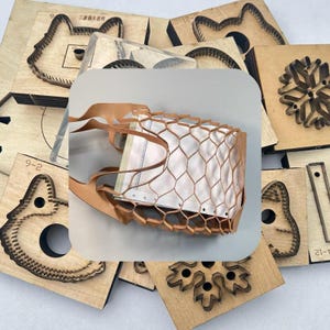 Könnte beinhalten: Eine hellbraune Lederhandtasche mit weißem Innenraum und einem einzigartigen Wabenmuster. Die Tasche ist von verschiedenen Holzstanzformen umgeben, darunter ein Schneeflocke, ein Gesicht und andere geometrische Formen. Die Tasche hat zwei Träger.