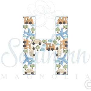 Op de afbeelding: Een geborduurde letter H in blauw en bruin met een patroon van vliegtuigen, treinen en bomen.