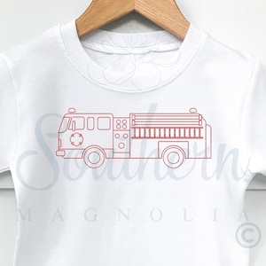 Può includere: Ricamo di contorno rosso di un camion dei pompieri su una maglietta bianca. Il design presenta una scala, ruote e una manichetta.