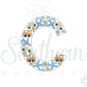 May include: An embroidered letter C in blue and brown with a design of aeroplanes, cars, trains, and trees around the letter.