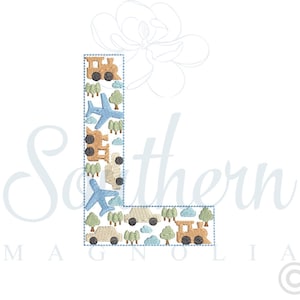 May include: A blue and white embroidered letter L with a pattern of airplanes, trains, and cars. The letter is surrounded by a blue outline.