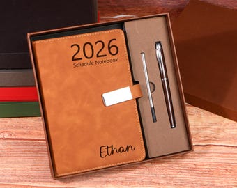 Puede incluir: Un cuaderno agenda 2026 de cuero sintético marrón con cierre plateado, personalizado con el nombre "Ethan". El conjunto incluye un bolígrafo y un recambio a juego, presentado en una caja de regalo.