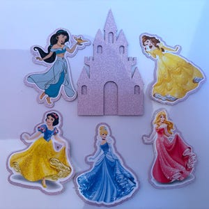 May include: A selection of princess-themed cutouts, including Jasmine, Belle, Snow White, Cinderella, and Aurora, alongside a glittery pink castle. The princesses are in their signature gowns, with a white outline.