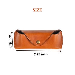 Puede incluir: Un estuche de gafas de cuero marr&oacute;n con cierre de bot&oacute;n a presi&oacute;n. El estuche mide 18,4 cm de largo y 7 cm de alto. La palabra "SIZE" est&aacute; impresa encima del estuche.