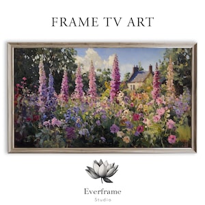 Puede incluir: Pintura enmarcada de un paisaje floral con un jardín vibrante de flores moradas y rosas, una casa de campo y un cielo azul. La obra de arte está etiquetada como "FRAME TV ART" y "Everframe Studio."
