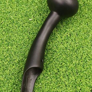 May include: A matte black, curved handle featuring a rounded, bulbous top and a tapered, hollowed-out lower section with a small circular opening near the base, designed for attachment to a larger mechanism or tool.
