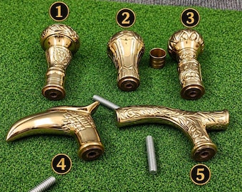 May include: Five polished brass walking stick handles with intricate embossed floral and leaf patterns. The collection includes three upright knob-style handles and two horizontal T-shaped handles, accompanied by two separate threaded metal screws.