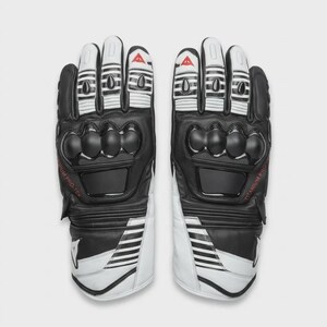 May include: Pair of black and white motorcycle gloves. The gloves have black knuckle protectors, white finger sections with black accents, and the text "TITANIUM PRO-TEK" in red. The gloves have a sporty design.