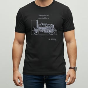 May include: Black t-shirt featuring a detailed blueprint of a steam carriage, with text that reads "STEAM CARRIAGE" and "Patented March 25, 1815." The design is in a light blue color, and the shirt is being worn.