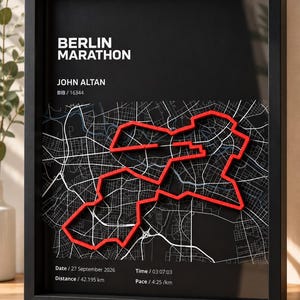 Könnte beinhalten: Ein gerahmtes Wandbild mit schwarzem Hintergrund, weißem Stadtplan von Berlin und einer erhabenen roten Linie, die die Marathonstrecke nachzeichnet. Der Text umfasst BERLIN MARATHON, JOHN ALTAN, BIB 16344, Datum 27. September 2026, Distanz 42,195 km, Zeit 03:07:03 und Pace 4:25 /km.