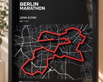 Op de afbeelding: Een ingelijst kunstwerk met een zwarte achtergrond, een witte stadsplattegrond van Berlijn en een verhoogde rode lijn die de marathonroute volgt. De tekst bevat BERLIN MARATHON, JOHN ALTAN, BIB 16344, Datum 27 september 2026, Afstand 42,195 km, Tijd 03:07:03 en Tempo 4:25 /km.