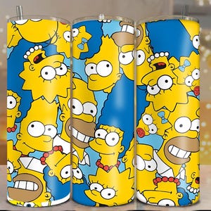 Op de afbeelding: Drie roestvrijstalen bekers met een levendig ontwerp met personages uit de tekenfilmserie The Simpsons. Het ontwerp bevat gele personages op een blauwe achtergrond. Elke beker heeft een rietje.
