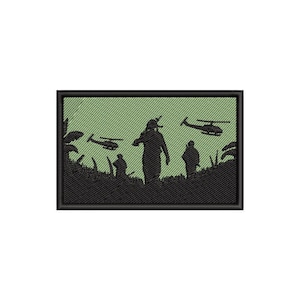 May include: Embroidered patch featuring a silhouette of soldiers in a jungle setting with helicopters overhead. The patch has a black border and a green background, depicting a military scene.